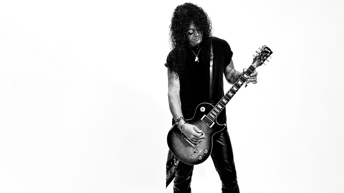 Slash playing guitar in black and white