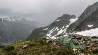 how to choose a backpacking tent: tent pitched in challenging conditions