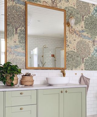 Green bathroom cabinet with large gold framed mirrors