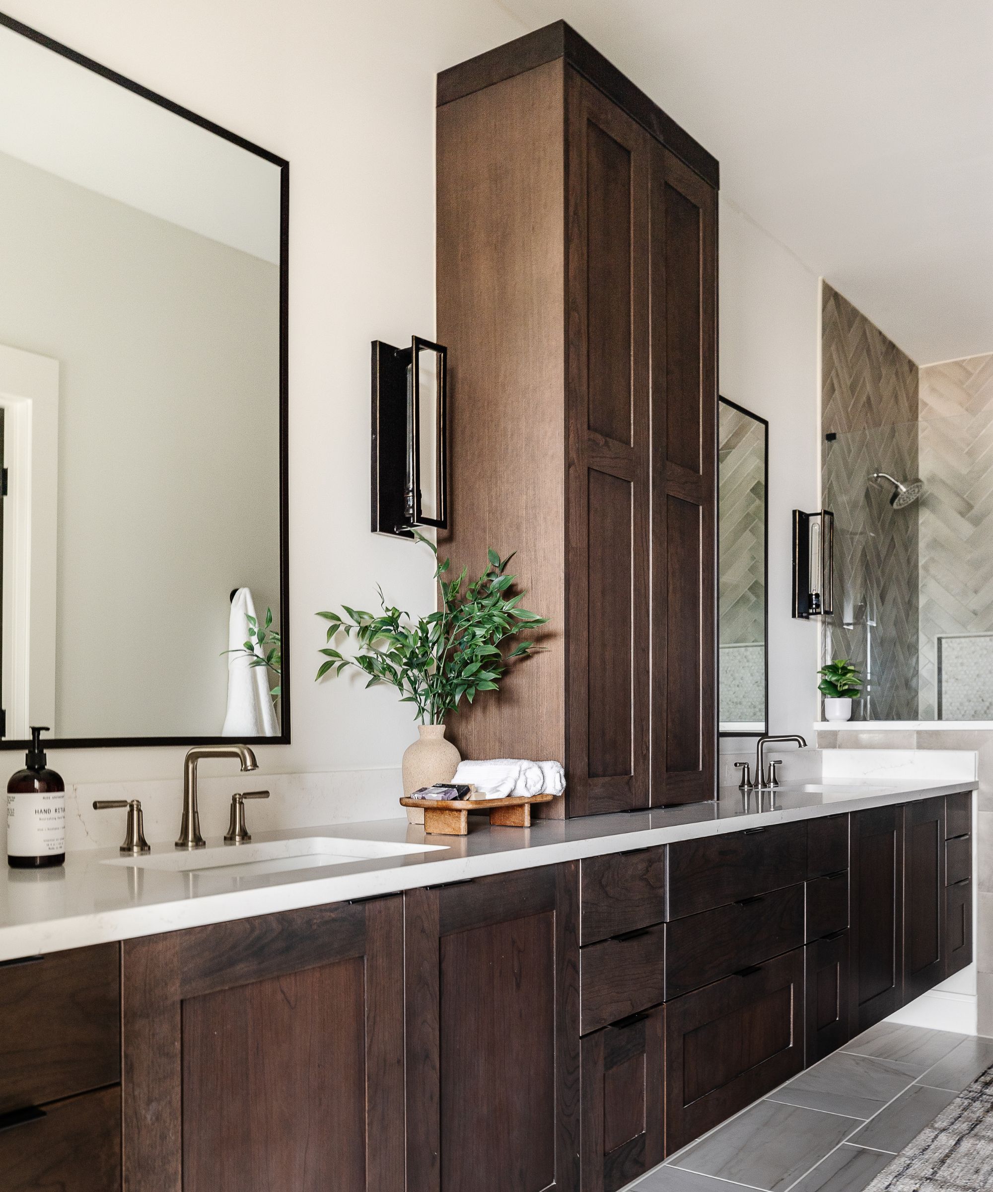A large bathroom painted Pure White by Sherwin-Williams and paired with dark wooden cabinets and vanity