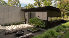 a chic outdoor area with a shed an a path and fireplace with wooden logs to sit on