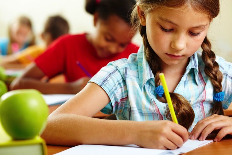 A girl does school work in a classroom.