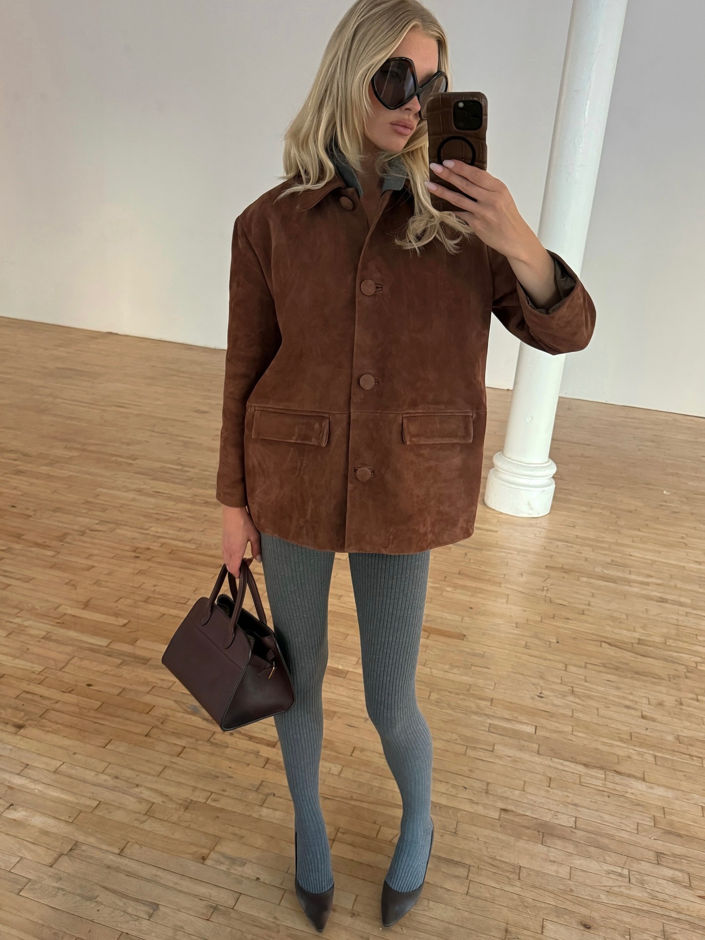 Elsa Hosk wearing a brown suede jacket and gray tights