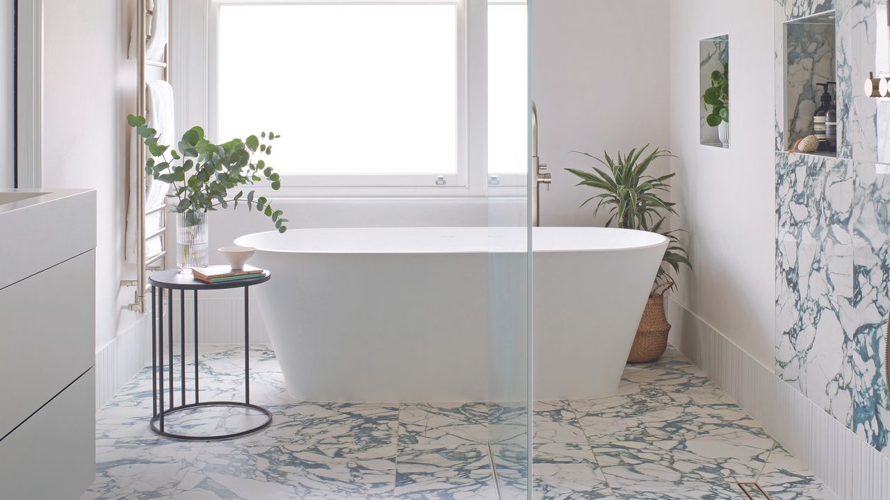 Bathroom with marble floor and freestanding white bath