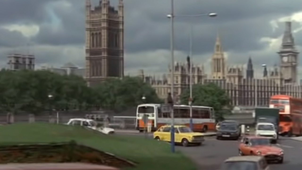 A yellow car driving around a roundabout in front of Big Ben and Parliament in European Vacation