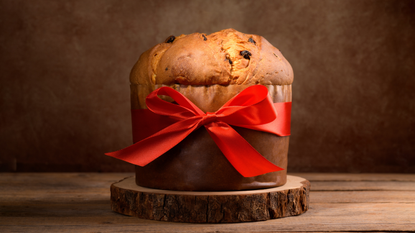 Panettone wrapped in brown paper and red ribbon.