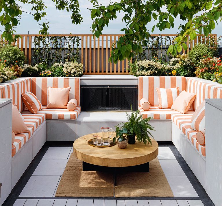 outdoor sofa and concrete seating area with orange and white stripe cushions