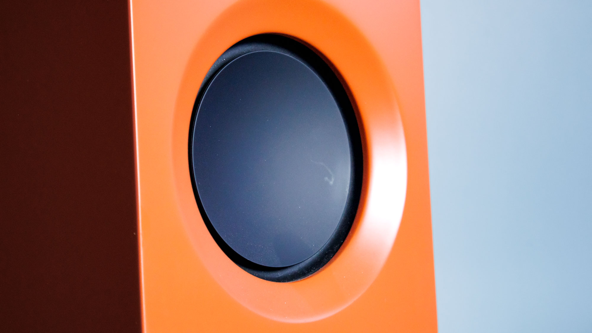 Closeup of the Kanto Ren speaker drive in front of a blue wall