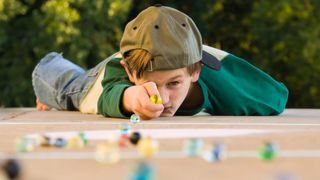 Boy shooting marbles