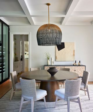 dining room with round wooden table and giant rattan pendant