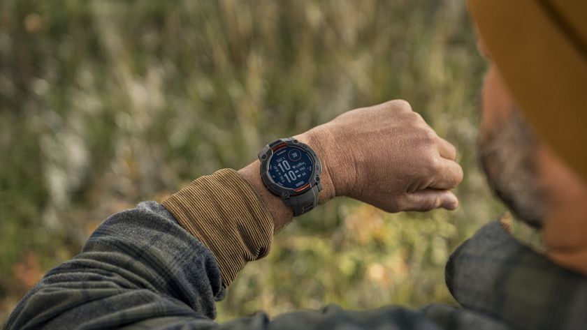 A photo of the Garmin Instinct 3 Solar on a man&#039;s wrist as he looks down at the main watch face