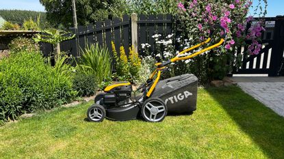 petrol mower in action on a sloped lawn