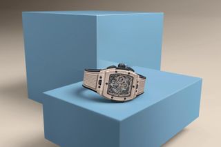 beige ceramic watch on blue plinth