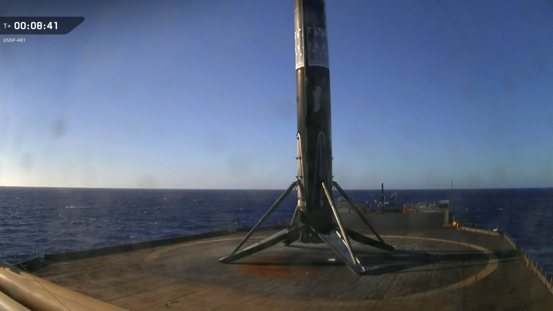 a black and white rocket rests on the deck of a ship at sea