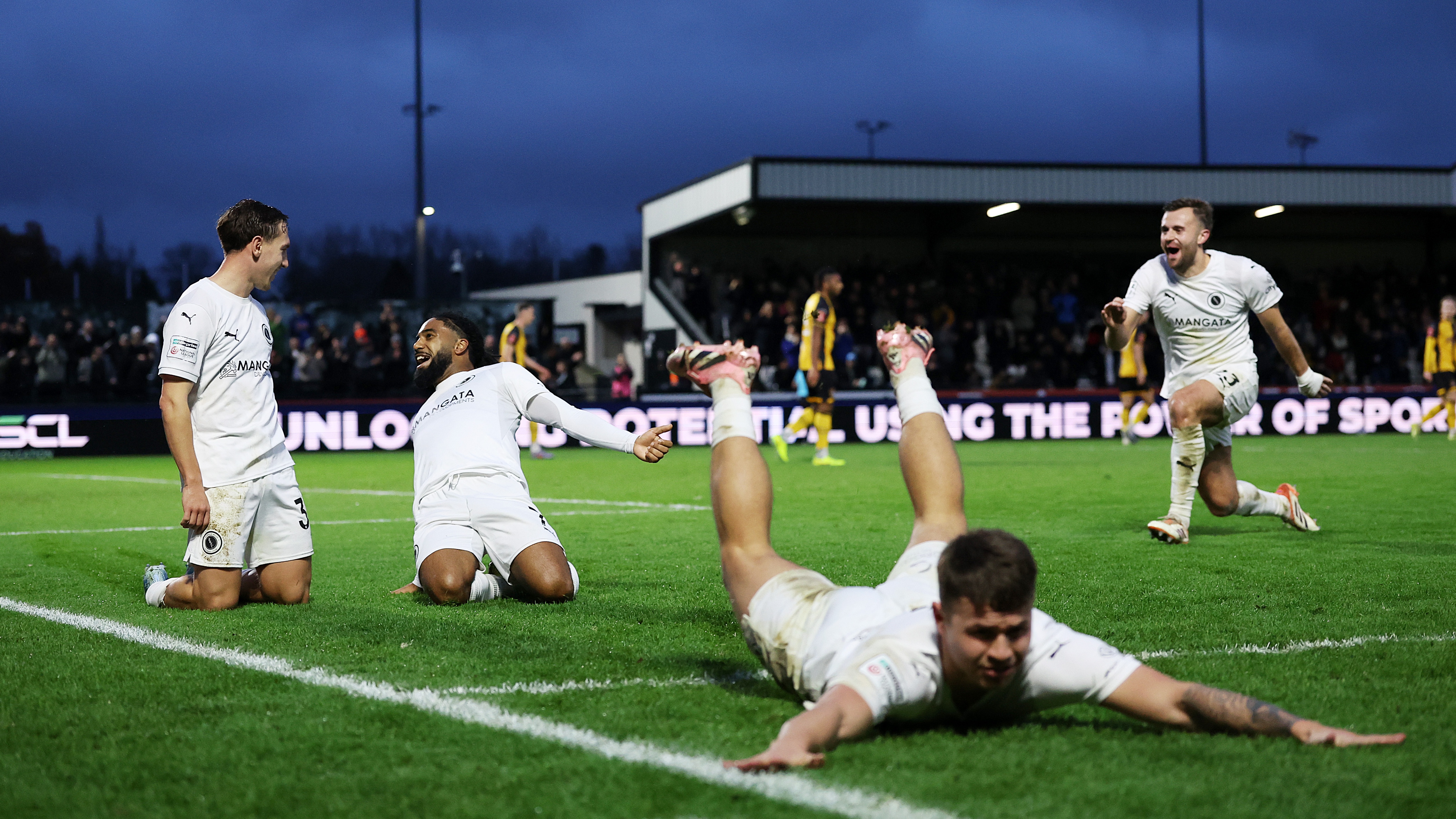 Matt Rush of Boreham Wood, left, celebrates with teammates after scoring his side's third goal during the Emirates FA Cup Second Round match between Boreham Wood and Newport County on December 07, 2025 in Borehamwood, England.