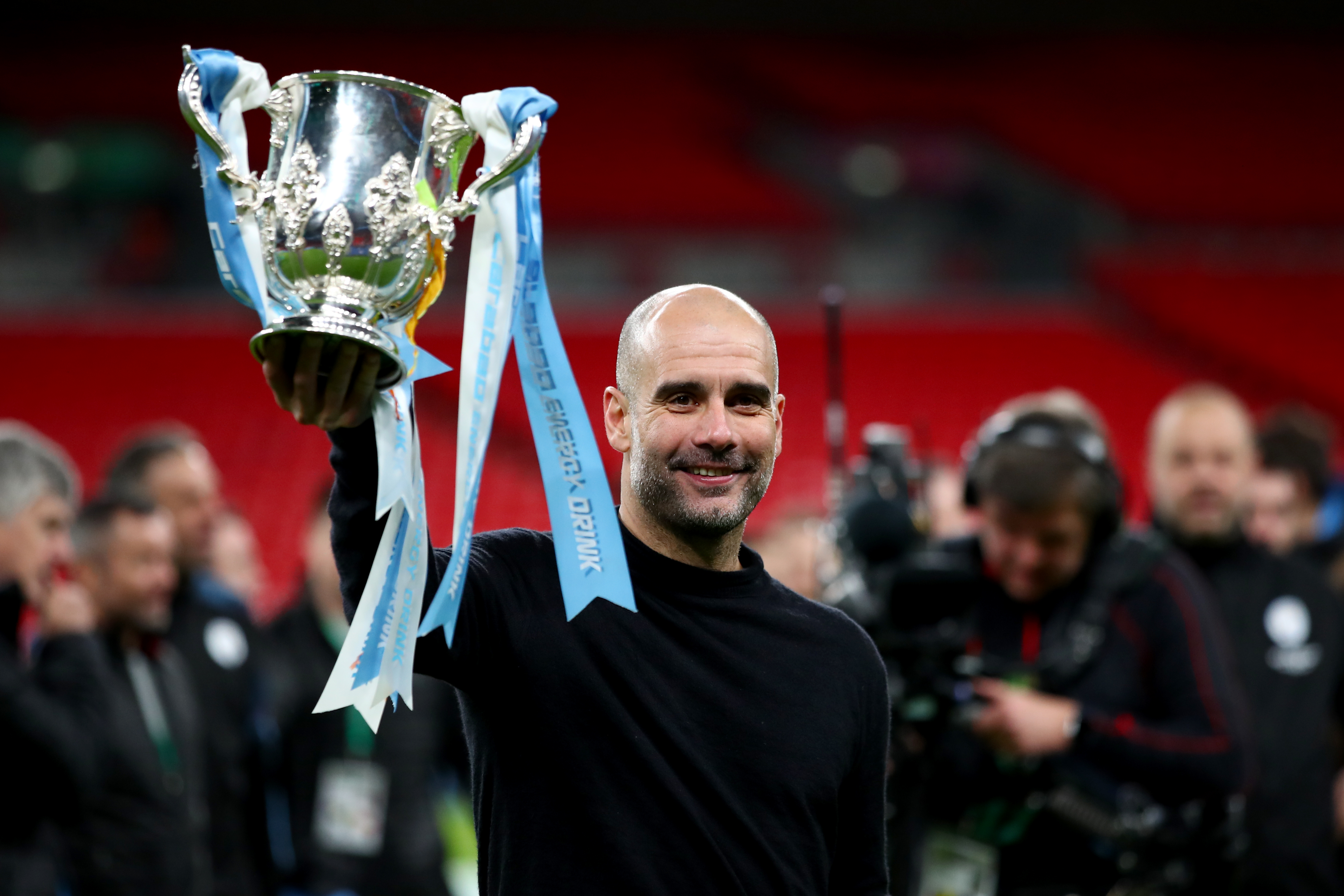 Pep Guardiola holds up the League Cup trophy after Manchester City's win over Aston Villa in the 2020 final at Wembley.