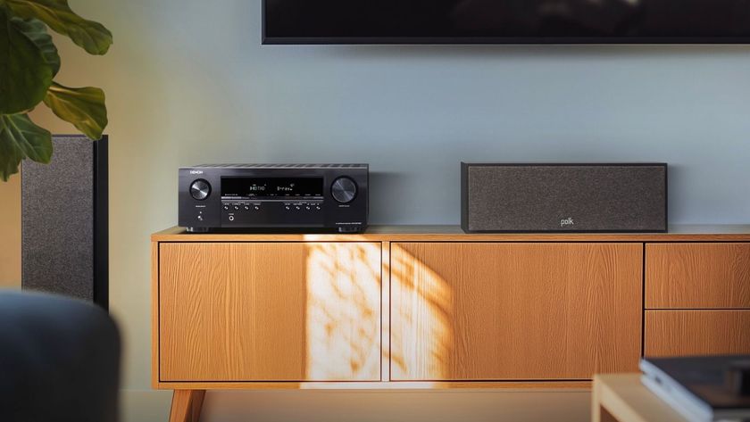 Denon AVR-S270BT AV receiver on a nice wooden sideboard with speakers on either side of it