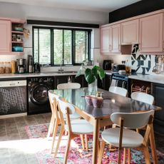 kitchen diner with pink cupboards and venetian blinds