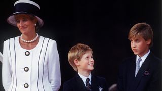 Princess Diana wearing a big white and blue hat and Tomasz Starzewski suit as she stands with her sons Prince Harry and Prince William at a parade to Commemorate the 50th Anniversary of VJ Day