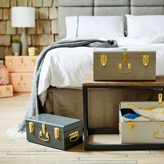 bedroom with metal trunks and wooden floor