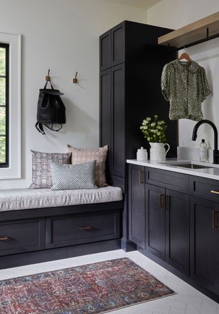 mud room with dark cabinetry and sink and bench seat