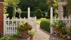 White picket fence and gated entrance to English summer garden