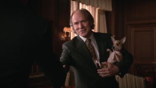 Will Patton shaking someone’s hand with his left hand and holding a small do with his right arm on The Good Wife.