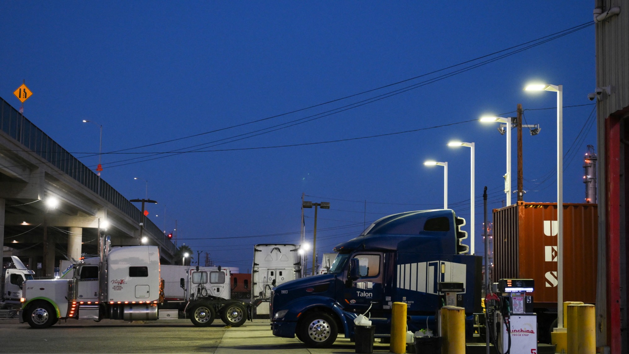 A truck is parked at a diesel fuel pump displaying prices above $8 per gallon 