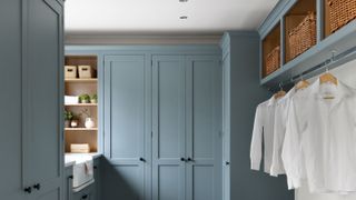 blue painted cupboards and shelves in utility room