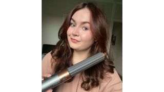 Freelance beauty editor Lucy holding the Dyson Airwrap after styling her hair