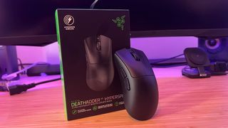 Razer DeathAdder V3 Hyperspeed mouse leaning up against its packaging on a wooden desk