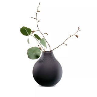 rounded black ceramic vase styled with foliage
