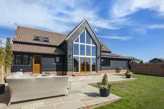 The exterior of a modern barn conversion with outdoor seating