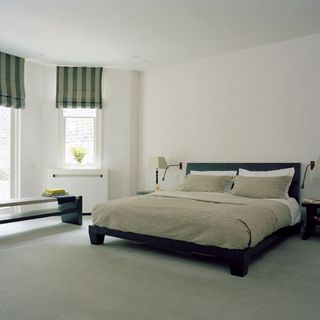 bedroom with white wall bed with designed cushion and grey floor