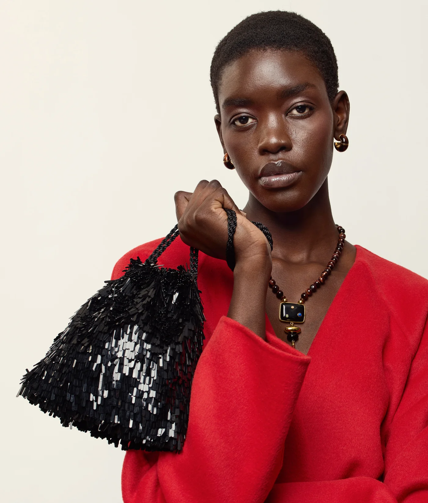 A Lizzie Fortunato model carrying a sequin evening bag