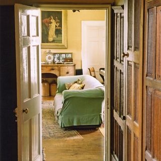 hallway with panelled wall and green sofa