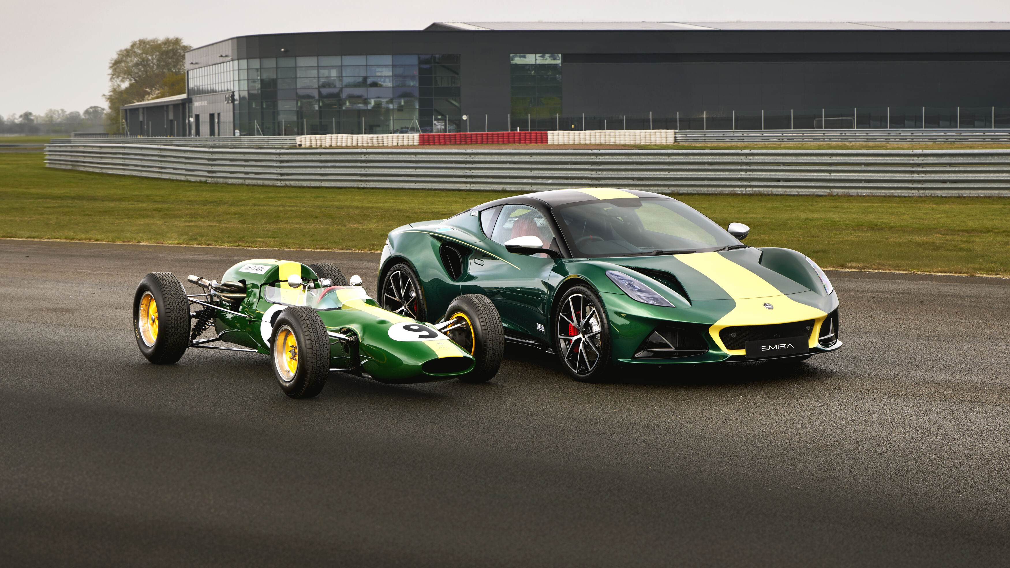 A Lotus Emira in a green and yellow livery, alongside a Jim Clark formula one car
