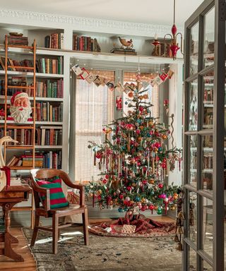 A Christmas tree decorated with vintage ornaments, dried orange slices, and colorful Mid-Century baubles