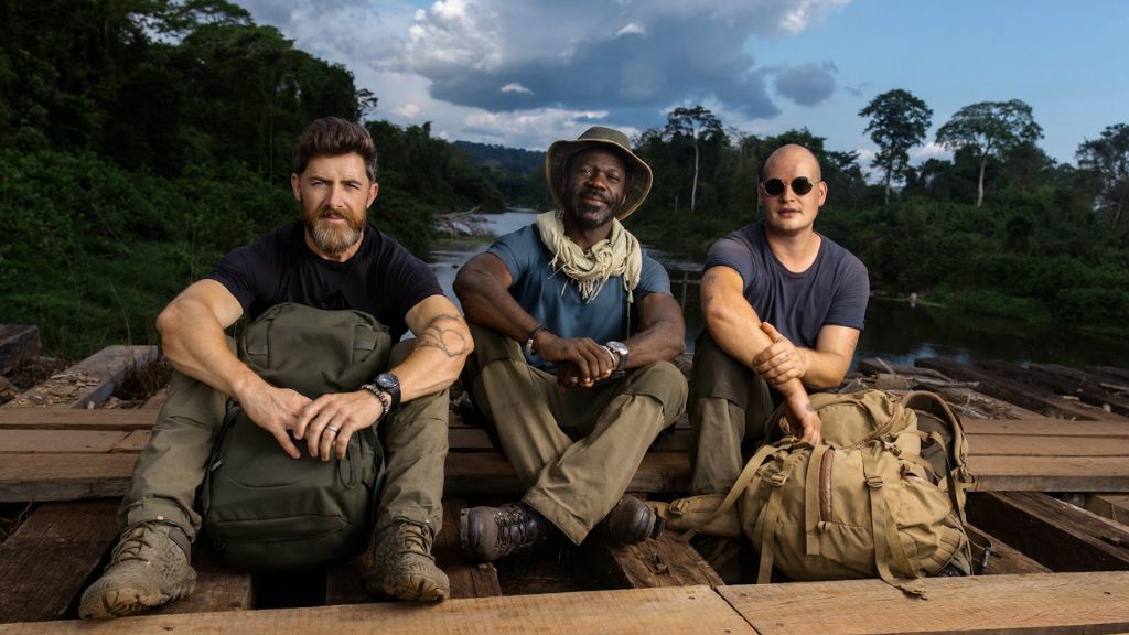 an image of Aldo Kane, Vianet Djenguet, and Declan Burley on a small wooden raft in a river in the jungle