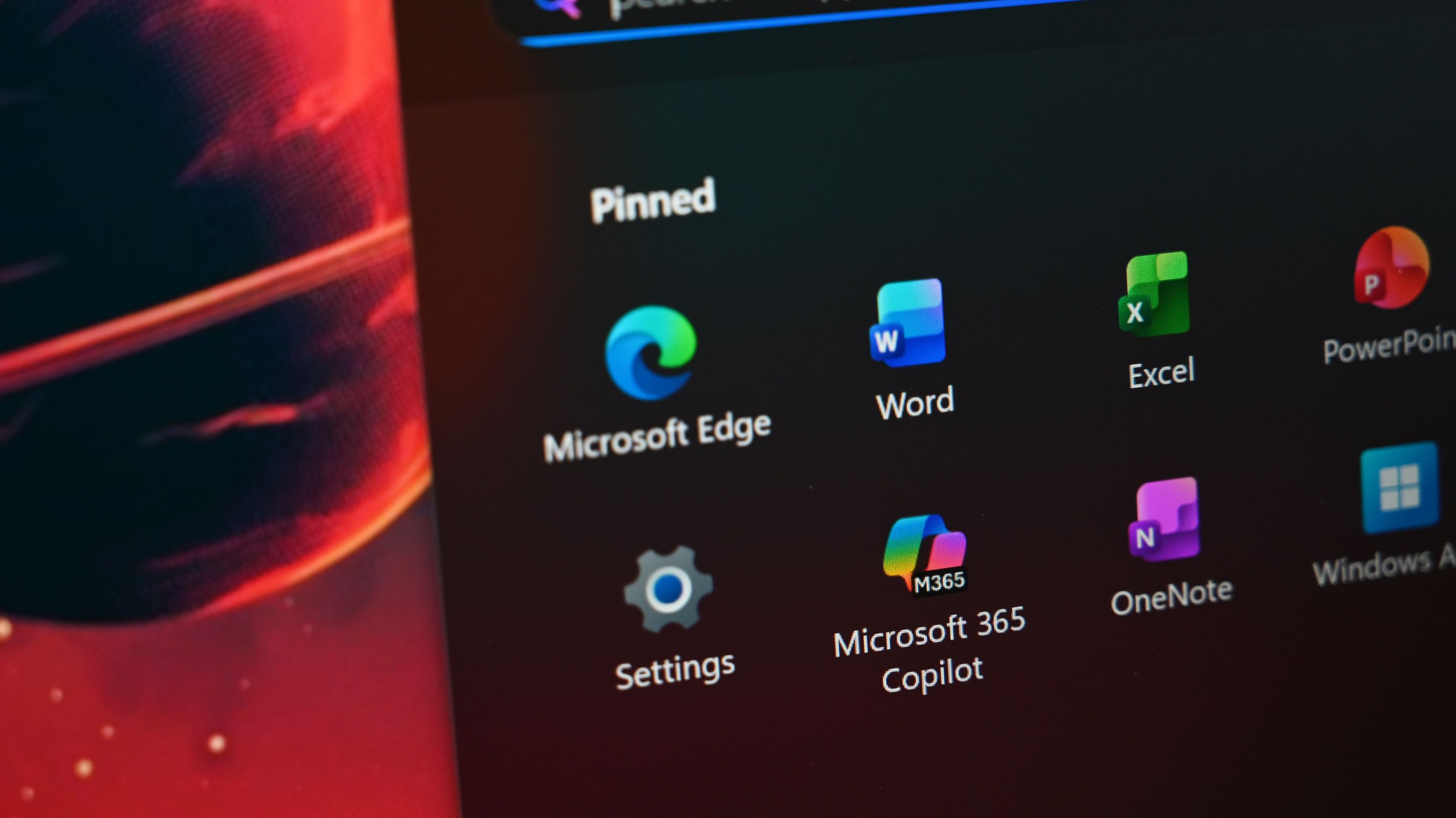 Close-up of Surface Laptop for Business 8th Edition desktop with pinned applications, including Microsoft Edge, Word, Excel, and Microsoft 365 Copilot. 