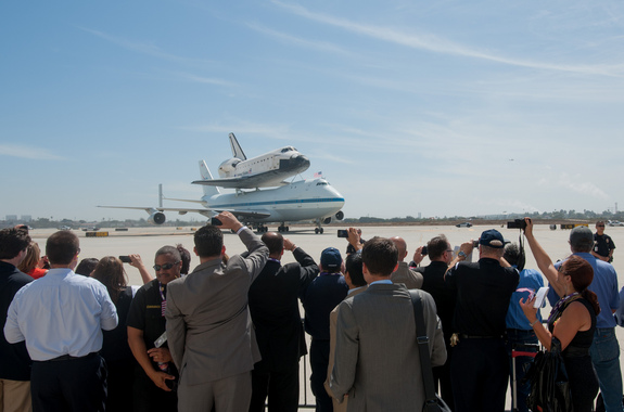 Spectators crowd the fence as the Shuttle Carrier Aircraft (SCA) carrying space shuttle Endeavour, taxis to the welcoming ceremony, Friday, Sept. 21, 2012, at Los Angeles International Airport.