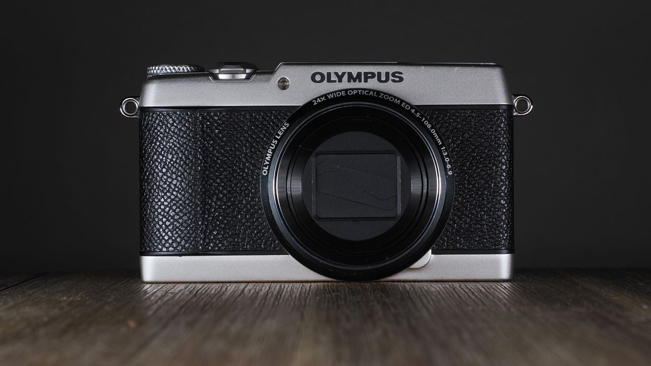 Olympus Stylus SH-3 on a wooden surface