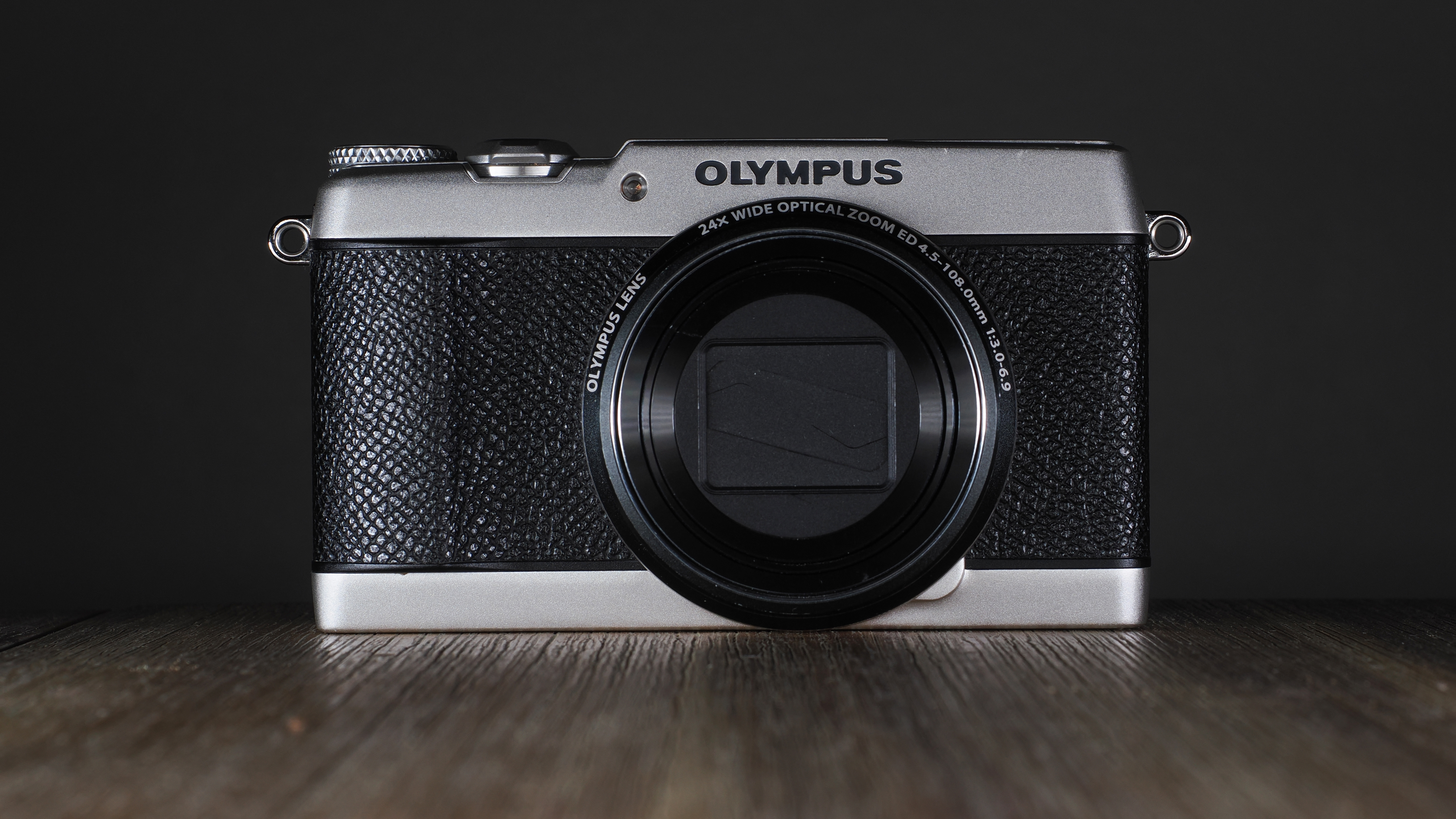 Olympus Stylus SH-3 on a wooden surface