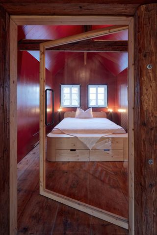 Cabin bedroom seen through entirely glazed open door