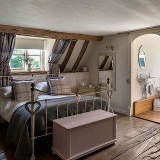 bedroom with wooden flooring and bed with pillows