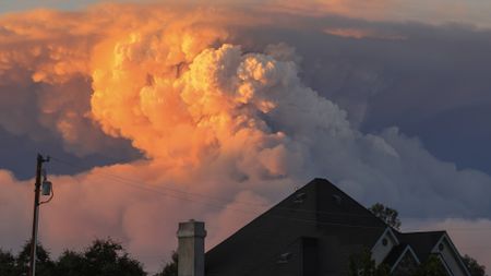 A cloud of smoke behind a suburban house