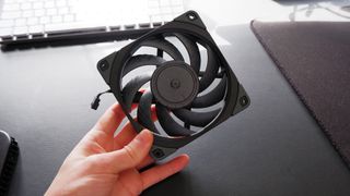 Noctua fans sitting on a desk with boxes.