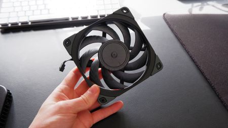 Noctua fans sitting on a desk with boxes.