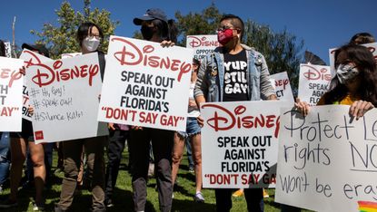 Protesters holding placards reading 'Disney - speak out against Don't Say Gay'