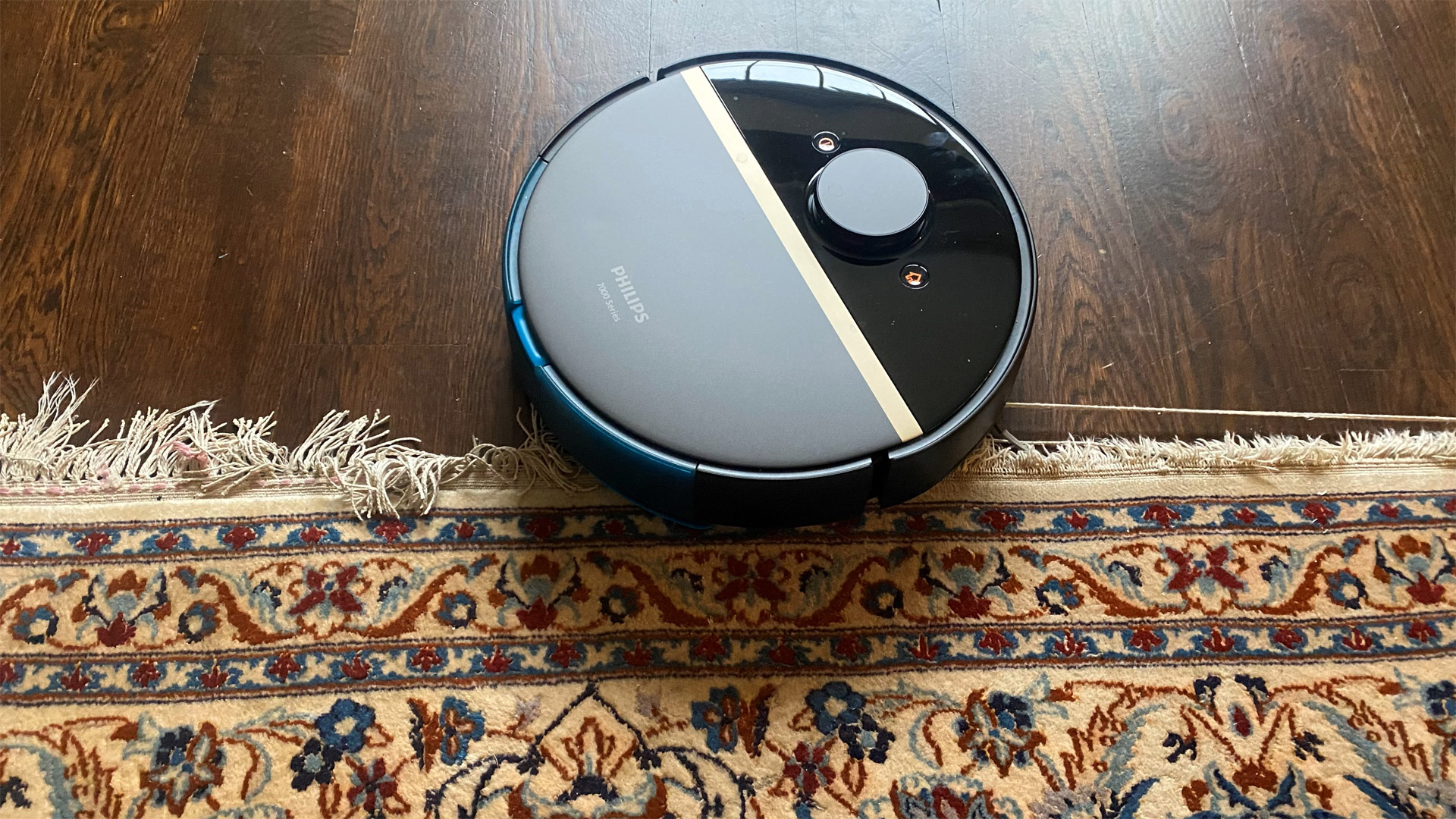 Philips HomeRun 7000 Series Aqua Vacuum and Mop Robot snagged on a rug's tassels